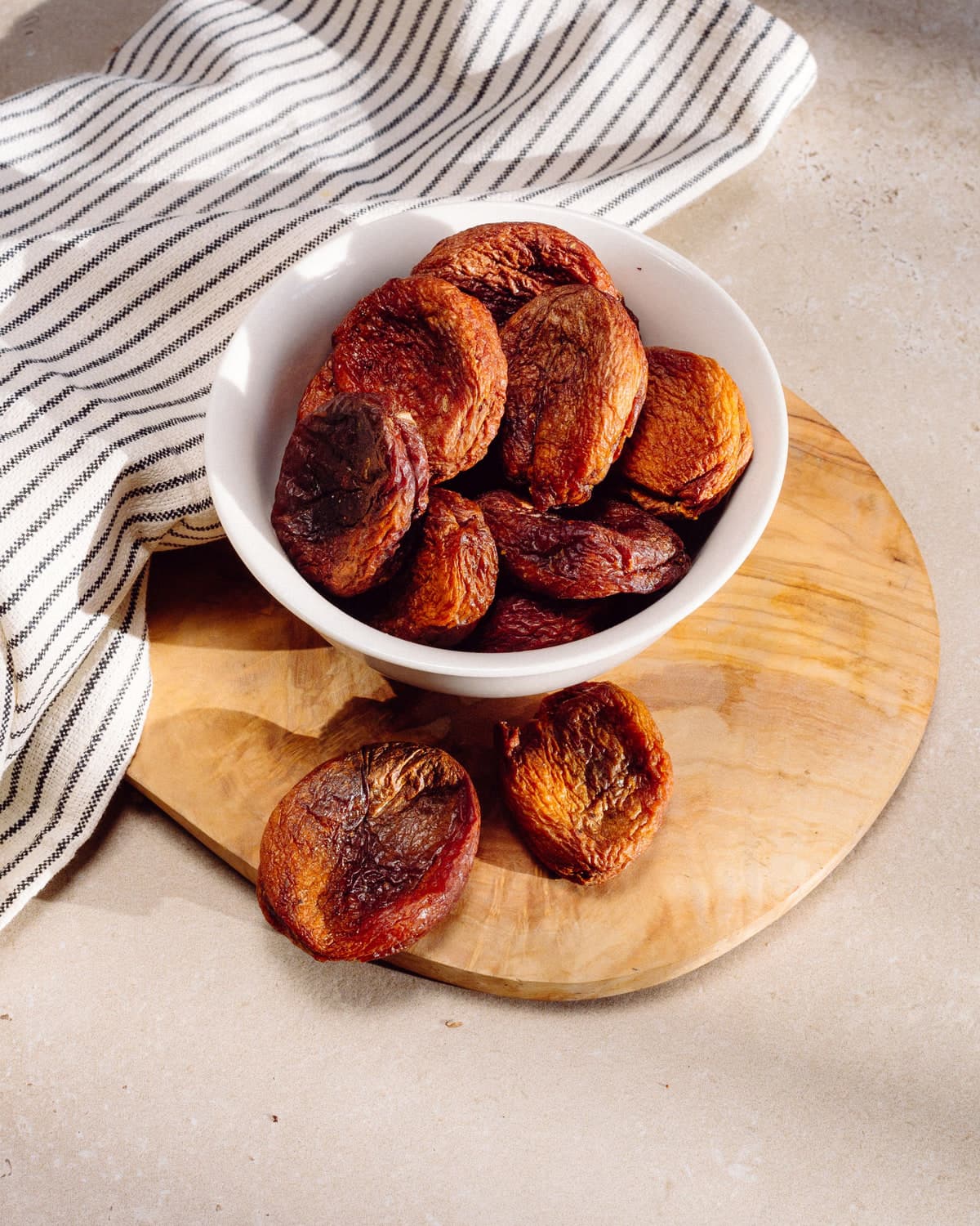 Brown round BM Afghani apricots in a white bowl