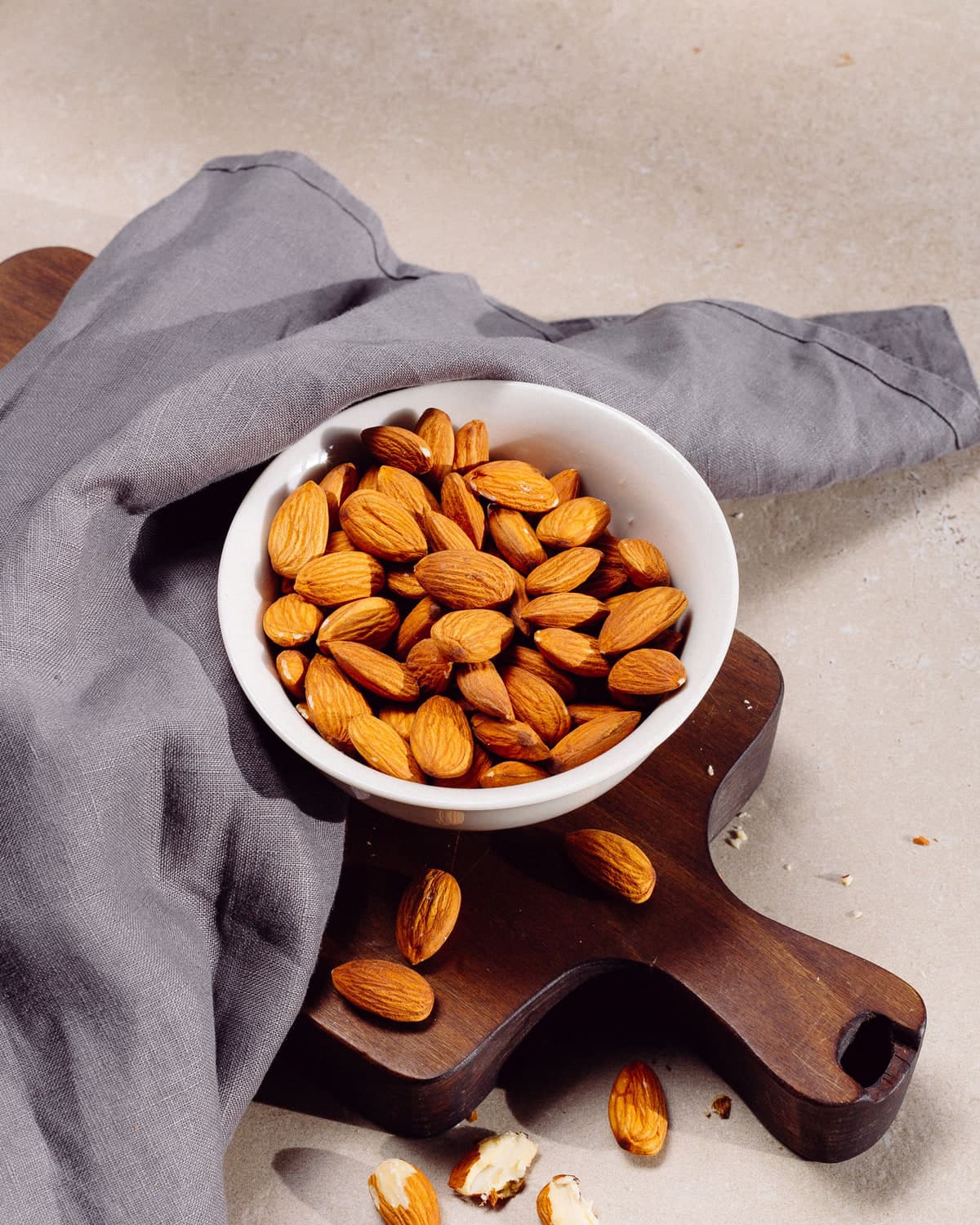 BM desi almonds in a white bowl on a wooden board