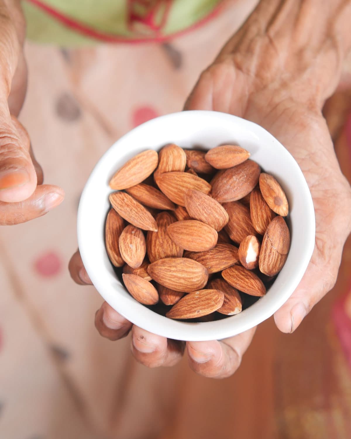 BM Far almonds in a white bowl held in two hands