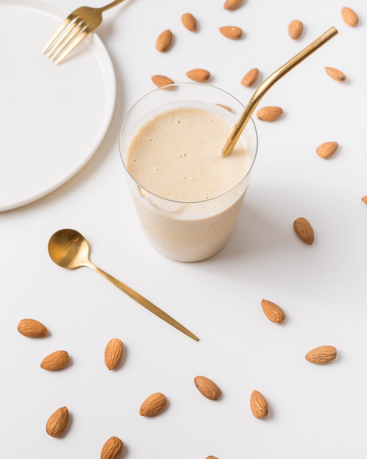 Almond shake with almonds scattered around it